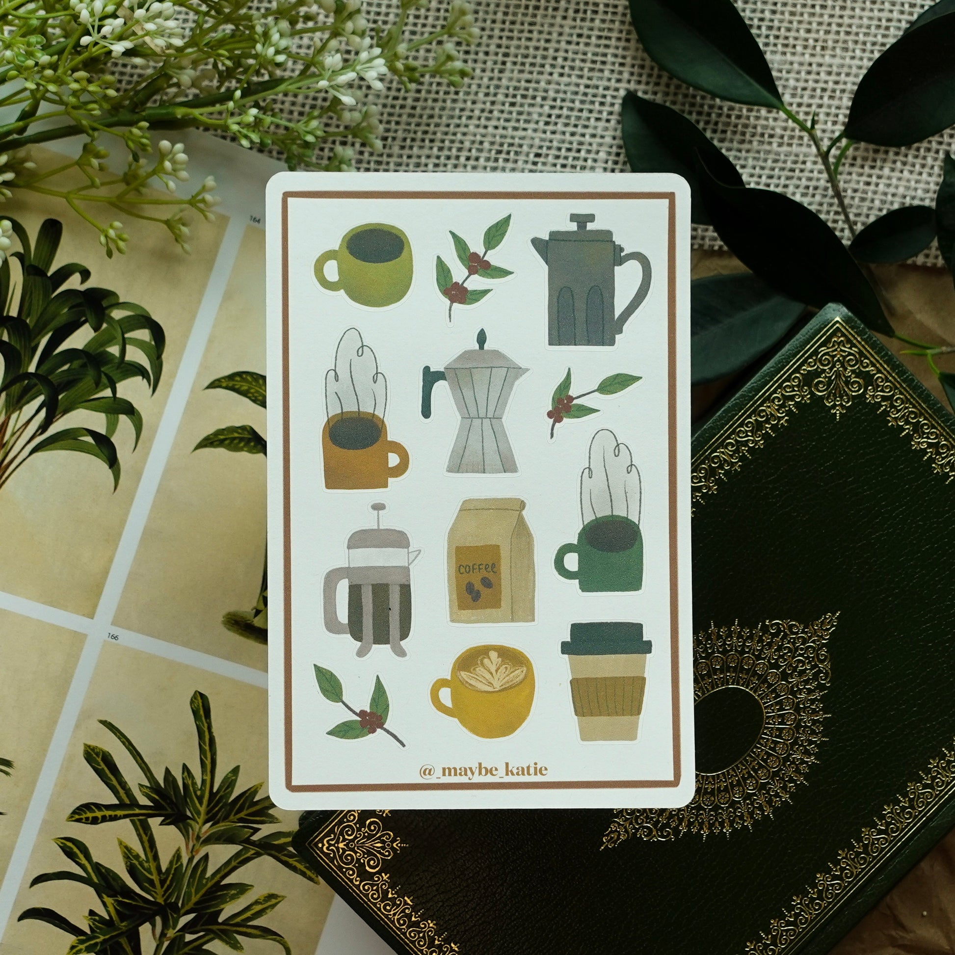Coffee-themed sticker sheet with botanical props behind it